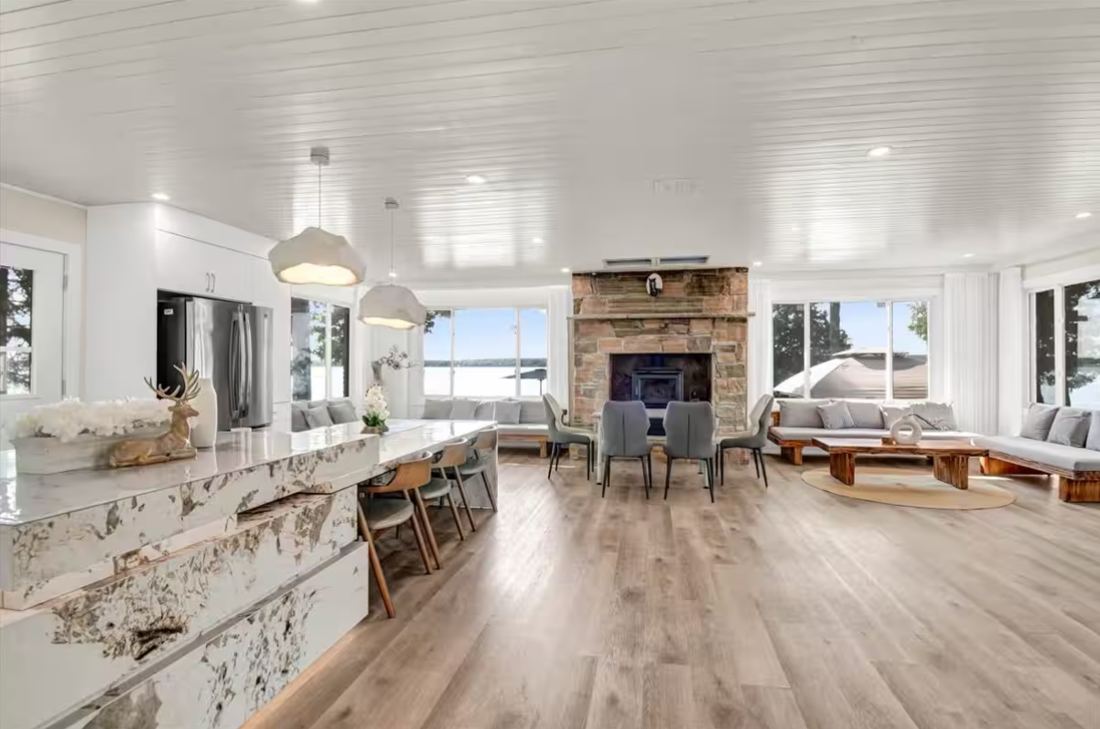Open living and dining room with stone fireplace