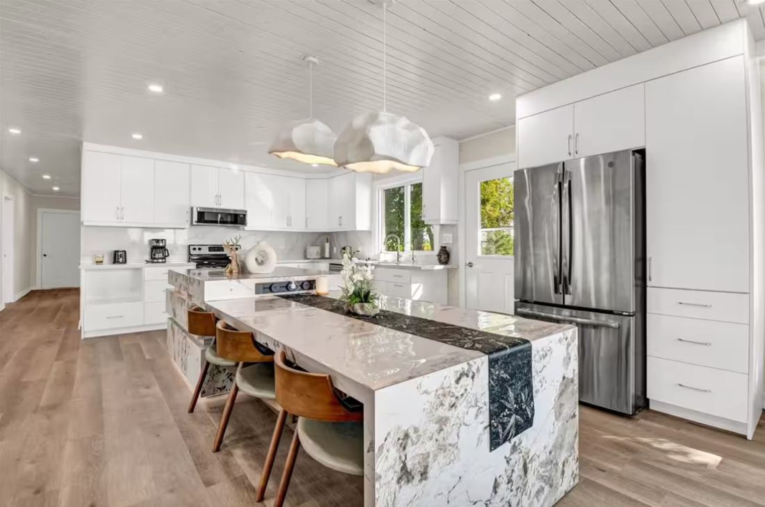 Kitchen with long marble island and wooden stools